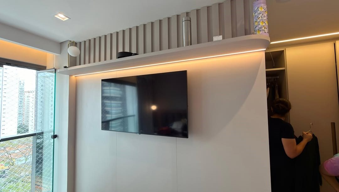 Televisor instalado em uma parede com acabamento texturizado